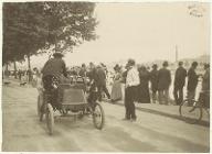 [Asnières-sur-Seine : pendant un combat naval sur la Seine 9 septembre 1900 : une voiture au premier plan et personnages debout le long de la Seine]